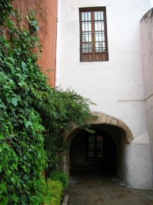 a stone building that has a bench in front of a house