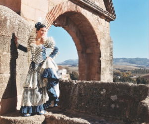 a statue of a person standing in front of a large rock