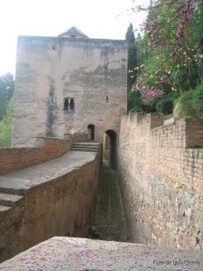 a close up of a stone building that has a bridge over a river